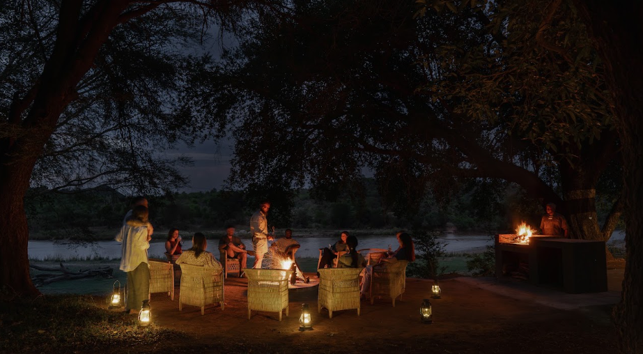 An evening fireside circle beneath the trees at Sashwa
